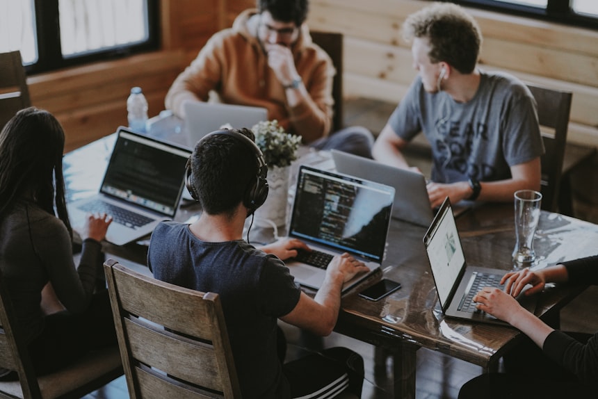 Design team collaborating on a website project around a laptop